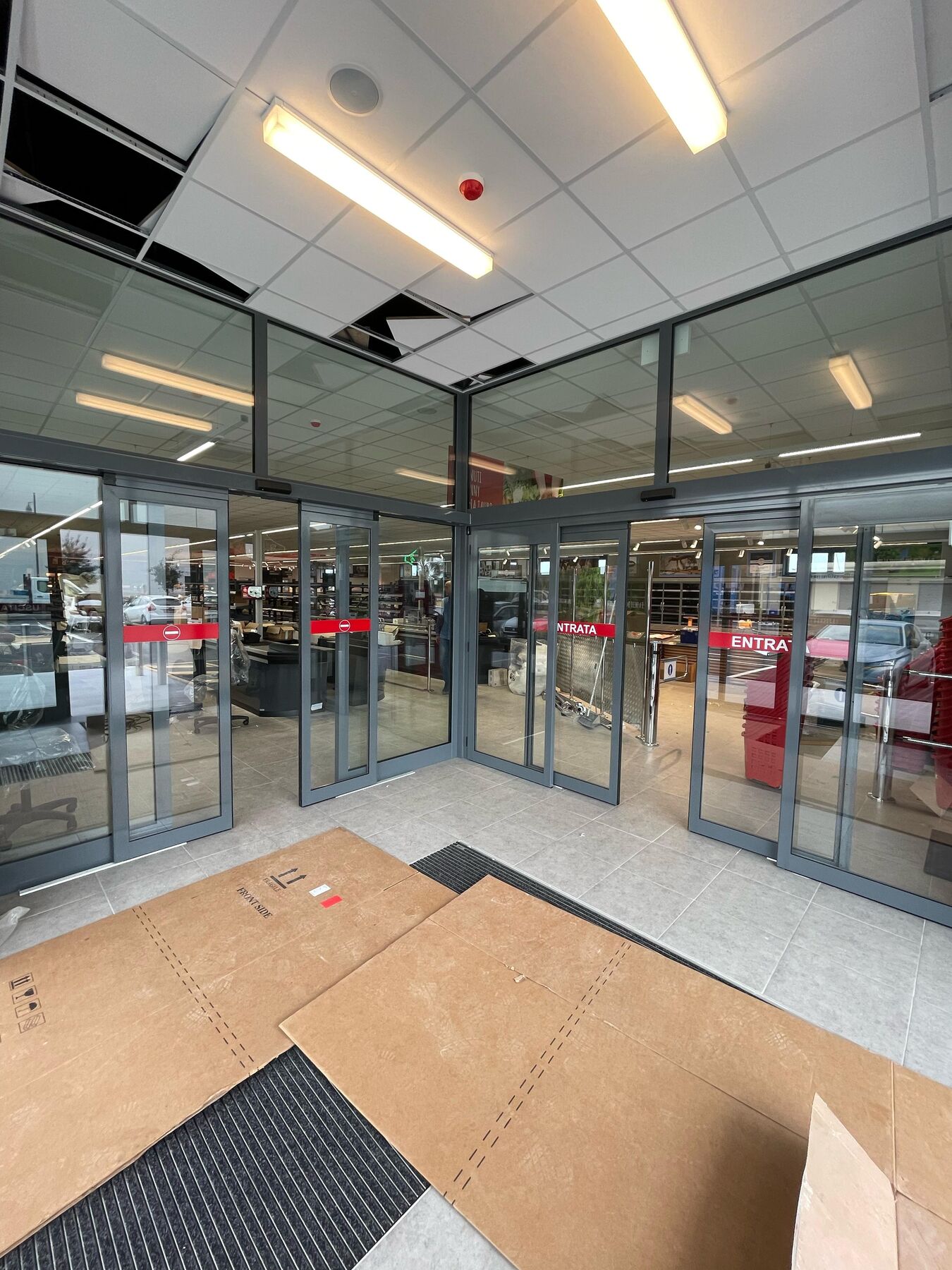 Porte scorrevoli automatiche ad angolo con ingresso e uscita separati in un supermercato